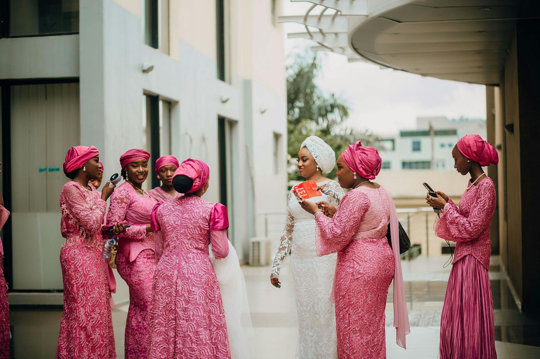 Panna młoda w bieli z druhnami w różowych sukniach w eleganckim wnętrzu