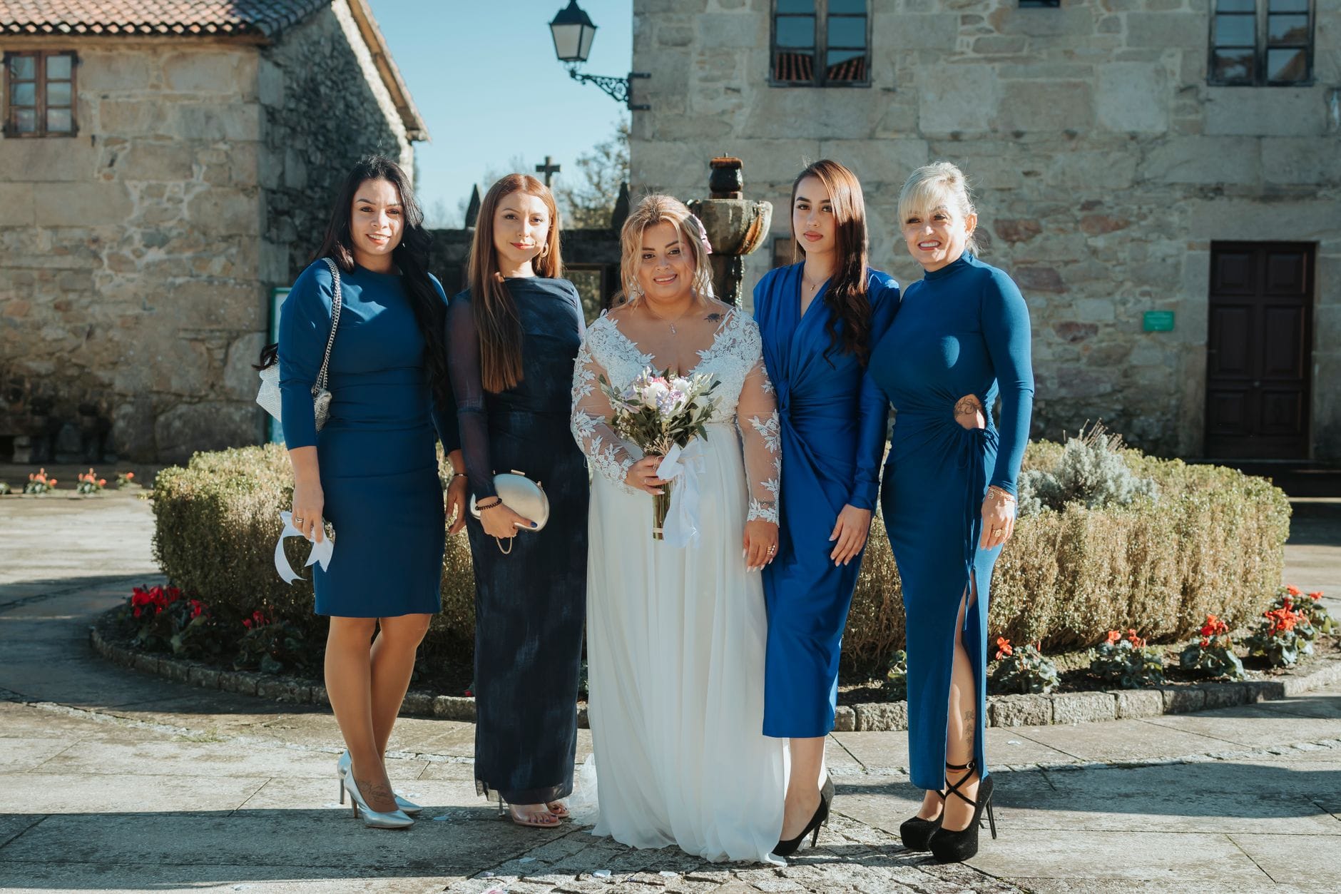 Panna młoda z druhnami w niebieskich sukienkach na zewnątrz
